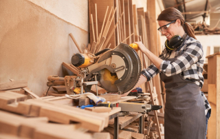 Une femme en tenue de bricolage effectue des tâches de menuiserie.