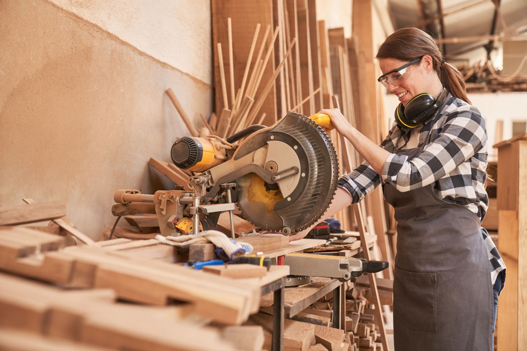 Une femme en tenue de bricolage effectue des tâches de menuiserie.
