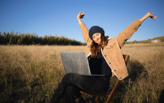 Une femme heureuse de travailler dans un champs de blé