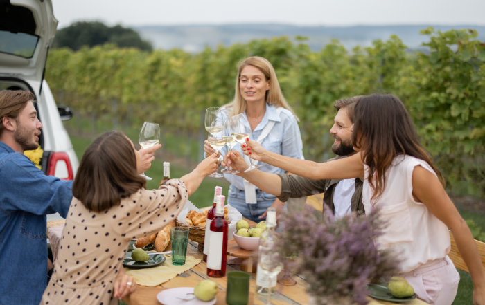 Un groupe d’amis partage un apéritif en extérieur, près de la mer, dans une ambiance détendue de fin de journée.