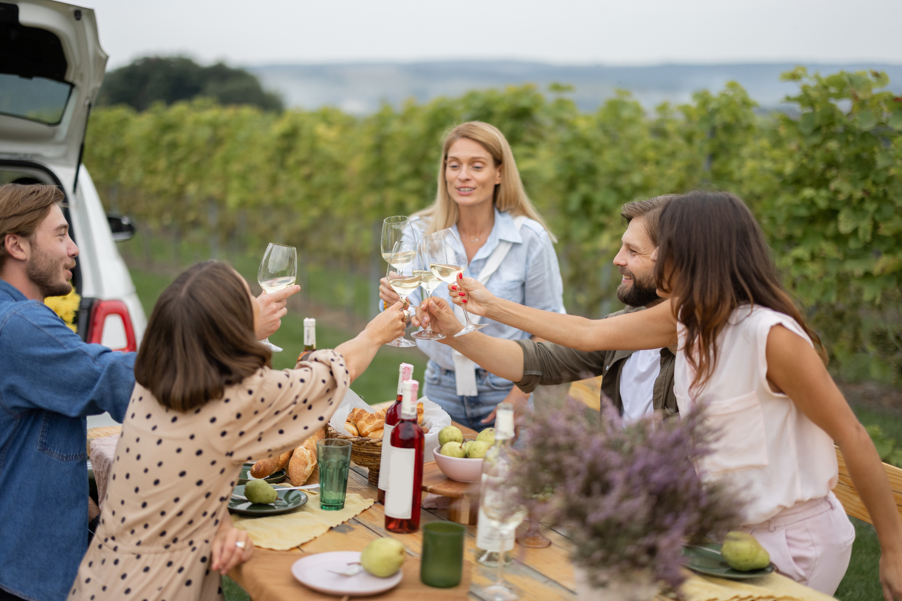 Un groupe d’amis partage un apéritif en extérieur, près de la mer, dans une ambiance détendue de fin de journée.