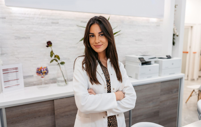 Une secrétaire médicale en blouse blanche à l'acceuil d'un centre de santé