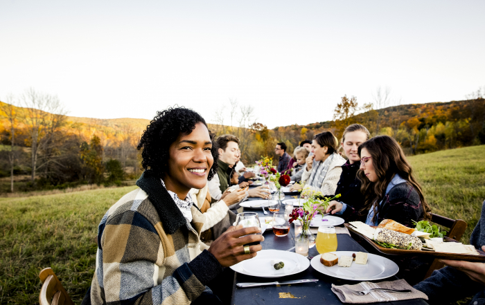 moment convivial : plusieurs amis qui déjeunent en extérieur, à la campagne