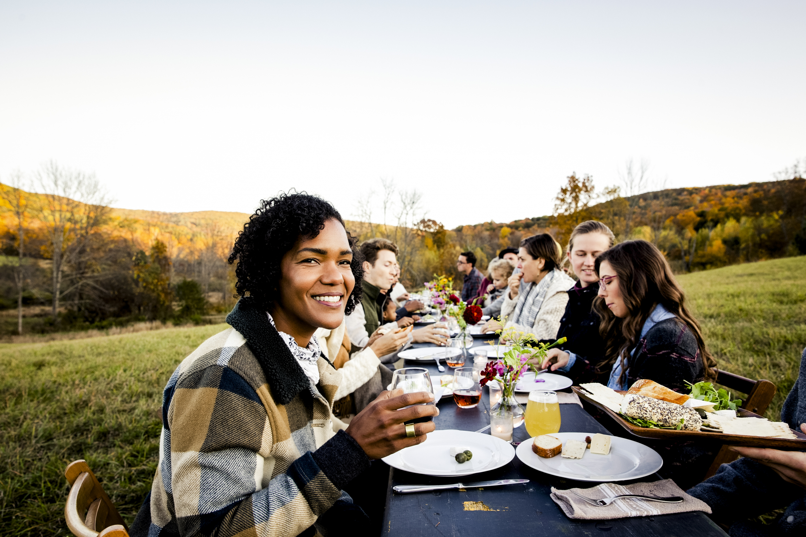 moment convivial : plusieurs amis qui déjeunent en extérieur, à la campagne