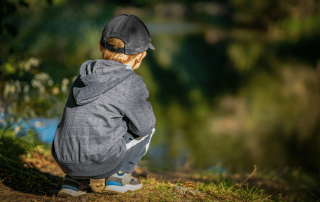 un enfant au bord de l'eau qui observe la nature
