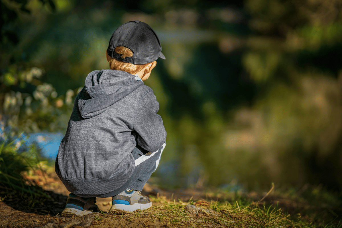 un enfant au bord de l'eau qui observe la nature