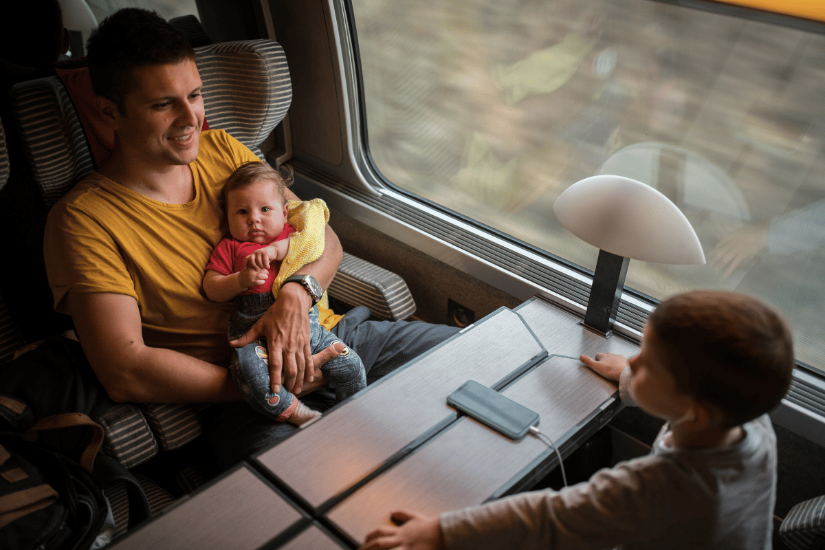 un papa et ses enfants dans un train pour une escapade en dehors de Paris