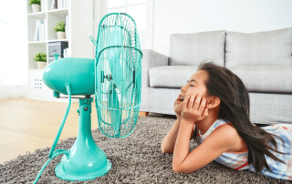 petite fille devant un ventilateur quand il fait trop chaud à l'interieur