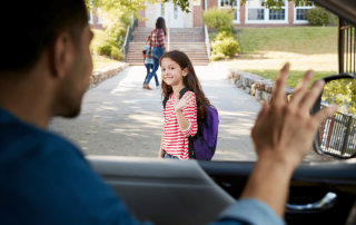 un papa qui dépose sa fille à l'école le matin