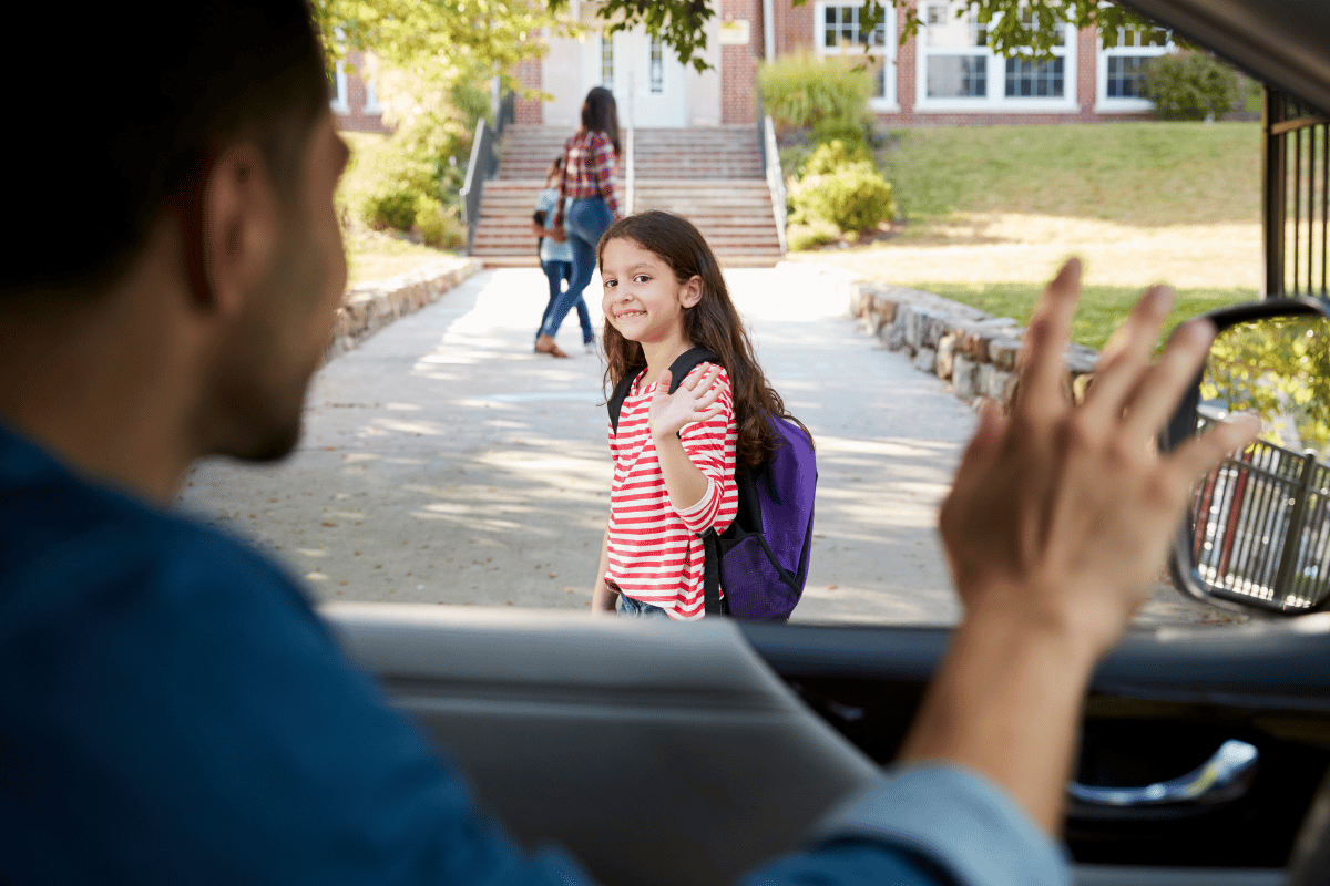 un papa qui dépose sa fille à l'école le matin