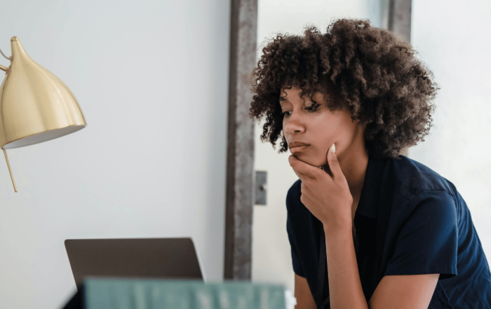 une femme qui réfléchir devant son ordinateur