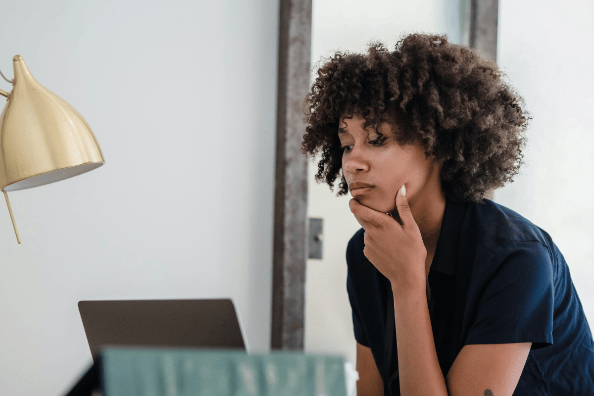 une femme qui réfléchir devant son ordinateur