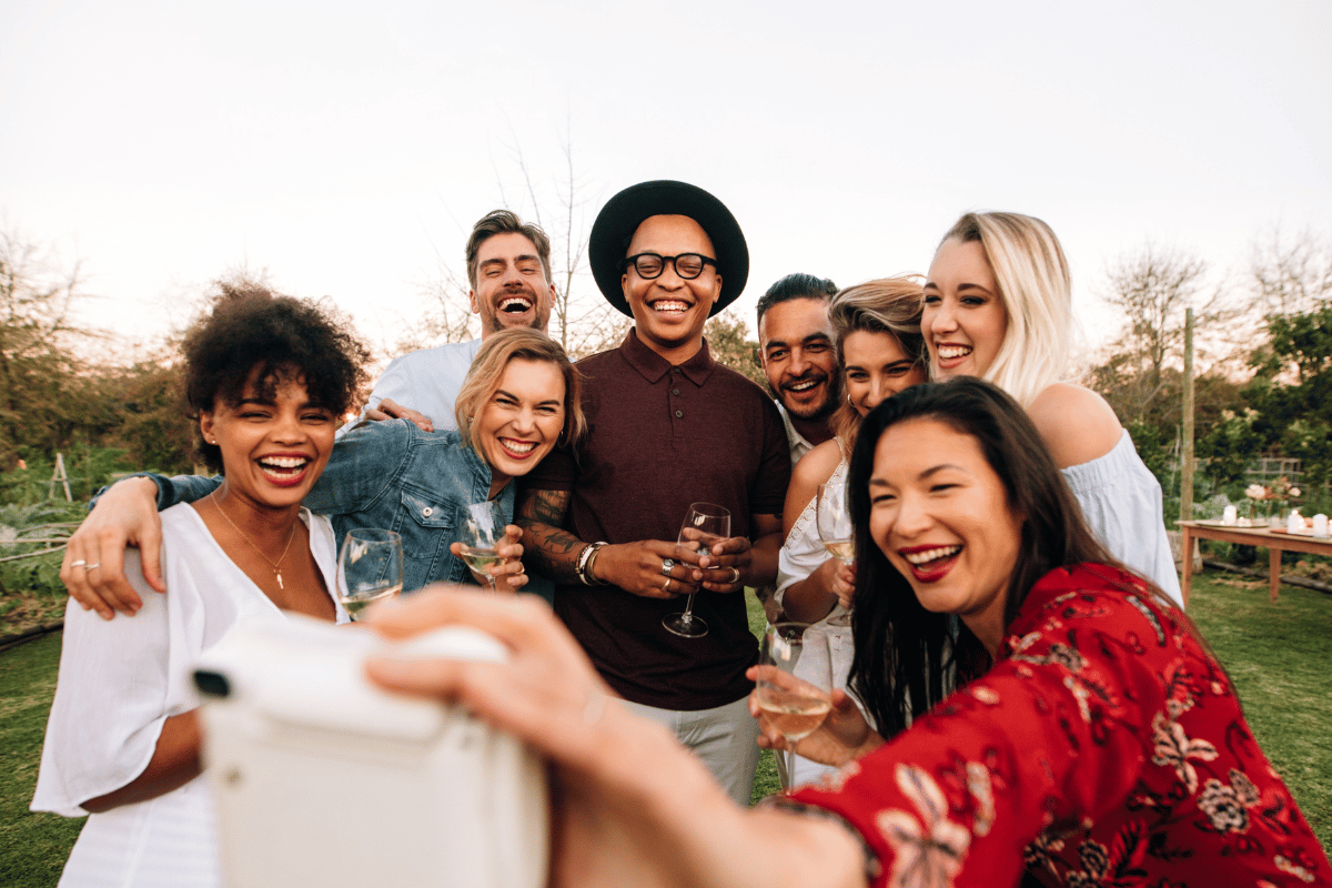 un groupe d'amis qui se prend en photo dans un jardin