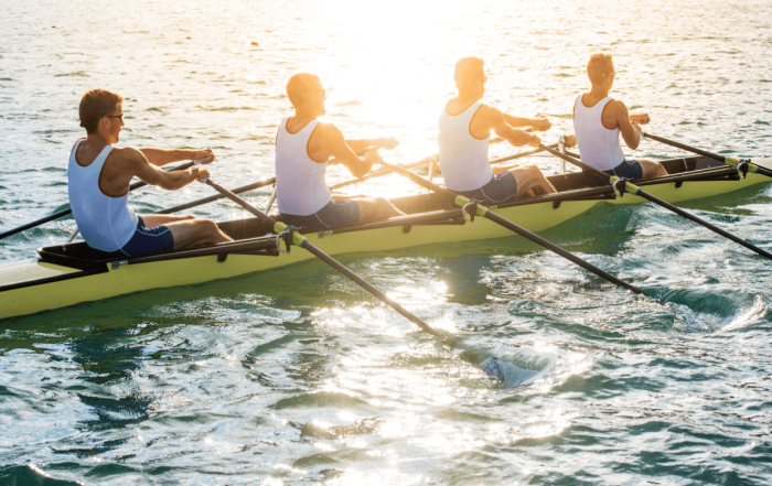 une équipe qui pratique l'aviron au coucher de soleil