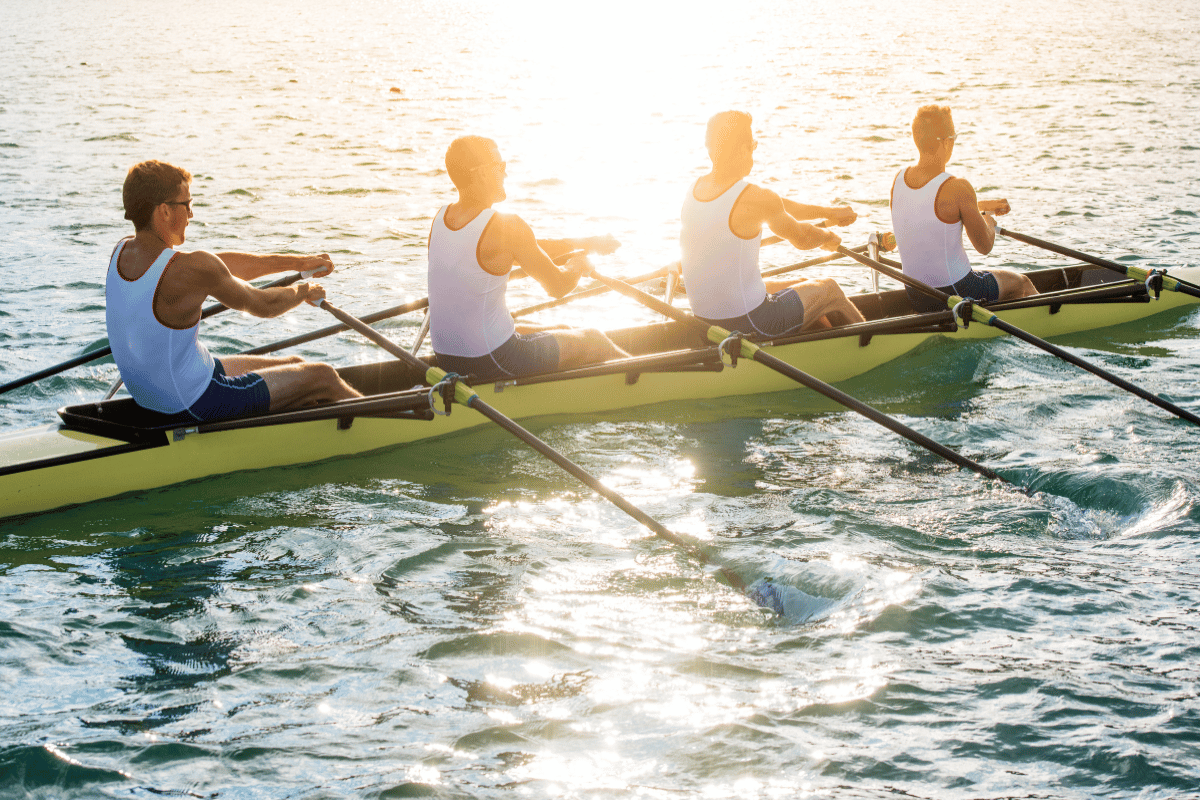 une équipe qui pratique l'aviron au coucher de soleil